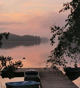 a dock with two boats on a lake at sunset at Muskoka Escape in Port Carling