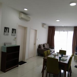 een woonkamer met een tafel en een bank bij Teega Cozy 2 Guests 35th floor WI-FI City View in Nusajaya