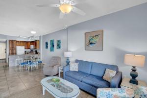 - un salon avec un canapé bleu et une table dans l'établissement Tidewater 702, à Orange Beach