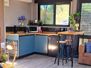 a kitchen with blue cabinets and a counter top at Moogie Pod - Trendy tiny getaway in Moogerah