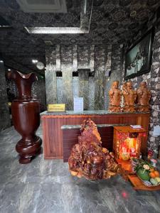 ein Zimmer mit einem Altar mit Statuen und einem Tisch in der Unterkunft Hang Chau Hotel in Cần Thơ