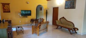 a living room with chairs and a flat screen tv at The Villa Marcelle in Negombo