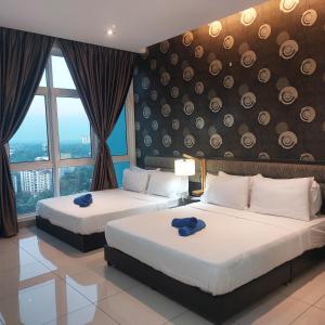 2 łóżka w pokoju hotelowym z dużymi oknami w obiekcie TWIN GALAXY JB Homestay by SUMMER w mieście Johor Bahru
