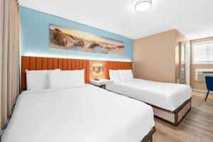 Habitación de hotel con 2 camas y escritorio en Mango Motel, en Wildwood