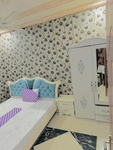 1 dormitorio con 1 cama y una pared con un patrón en RÉSIDENCE ACHIKA INELIA, en Bobo-Dioulasso