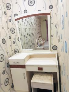 ein Bad mit einem Waschbecken und einem Spiegel in der Unterkunft RÉSIDENCE ACHIKA INELIA in Bobo-Dioulasso