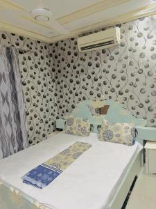 Bett in einem Zimmer mit einer Wand in der Unterkunft RÉSIDENCE ACHIKA INELIA in Bobo-Dioulasso