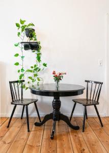 una mesa con dos sillas y un jarrón con flores en Boutique Altbau Apartment en Berlín