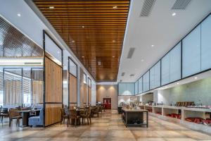 un restaurante con techos de madera, mesas y sillas en Phoenix Hill Hotel Dongguan - Golf Course Shop, en Dongguan