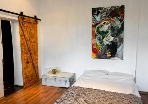 1 dormitorio con 1 cama y una pintura en la pared en Boutique Altbau Apartment en Berlín