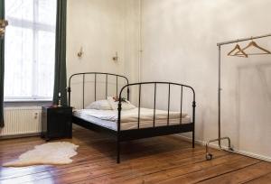 a bedroom with a metal bed in a room at Boutique Altbau Apartment in Berlin