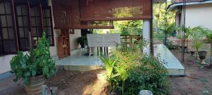 a porch of a house with plants and a chair at The Villa Marcelle in Negombo