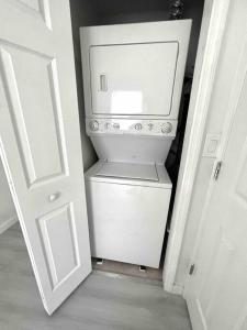 a small kitchen with a white refrigerator in a hallway at Modern cozy with pool and big backyard in Tampa