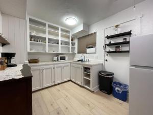 cocina con armarios blancos y nevera blanca en Sierra Mountain Lodge - Vacation Rentals - Yosemite en Ahwahnee