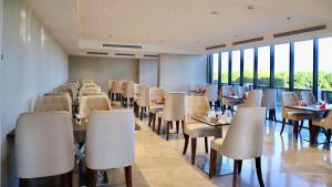 Five Seasons Hotel في تبوك: غرفة طعام مع طاولات وكراسي ونوافذ