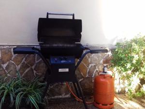 a grill and a fire hydrant next to a wall at Can Pedro Ros - House In S'illot-cala Morlanda Free Wifi in S'Illot