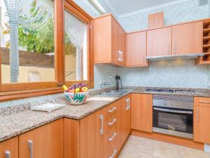 a kitchen with wooden cabinets and a bowl of fruit on the counter at Can Pedro Ros - House In S'illot-cala Morlanda Free Wifi in S'Illot
