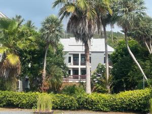 une maison blanche avec des palmiers devant elle dans l'établissement Samui Seabreeze Place, à Lamai