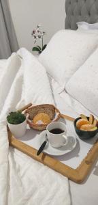 a tray of food and a cup of coffee on a bed at Apartamento para locação em Itajai SC in Itajaí