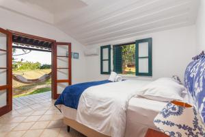 a bedroom with a bed and a sliding glass door at Casa Sol Búzios in Armacao dos Buzios