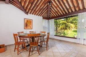 a dining room with a table and chairs and a large window at Casa Sol Búzios in Armacao dos Buzios