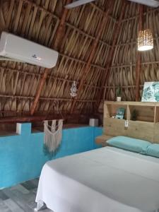 a room with a bed in a straw hut at El Puente in El Paredón Buena Vista