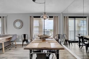 a dining room with a table and chairs and windows at Windward Pointe 706 in Orange Beach