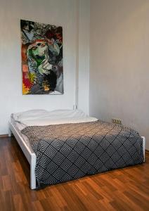 un letto in una stanza con un dipinto sul muro di Artistic Altbau Apartment a Berlino