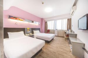 Postel nebo postele na pokoji v ubytování Motel Xiamen Railway Station