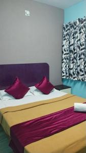 a bedroom with a bed with two red pillows at Misty Stay by Le Apex in Ooty