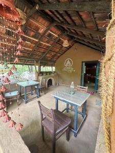 a patio with tables and chairs and a fireplace at Ali Adi Eco Lodge in Sigiriya