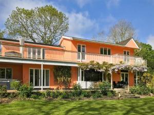 an orange house with a balcony and a yard at Dunburgh Wood in Beccles