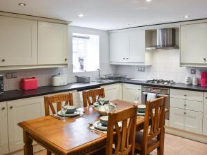a kitchen with a wooden table and chairs at The Towers in Witton le Wear