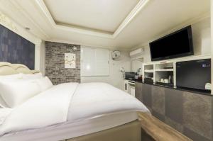 Nobless Motel في Sin-ni: غرفة نوم بسرير كبير وتلفزيون بشاشة مسطحة
