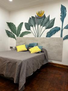 a bed with yellow and blue pillows in a room at JURAMA in Ciudad Lujan de Cuyo