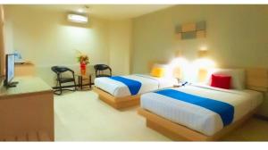 a hotel room with two beds and a kitchen at Merpati Hotel in Pontianak