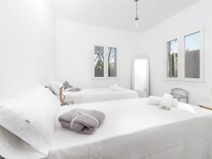 two beds in a room with white walls and windows at Cala Rafalino - House In S'illot-cala Morlanda Free Wifi in S'Illot