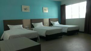 um quarto de hotel com duas camas e uma janela em MJ Hotel em Sibuga