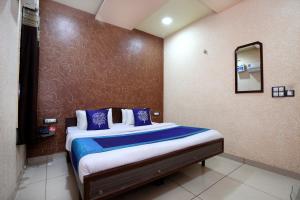 a bedroom with a large bed with blue pillows at OYO 9808 Hotel Prem Sagar in Ludhiana