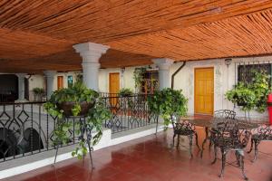 porche con mesas y sillas y techo de madera en Hotel Anua Oaxaca, en Oaxaca City