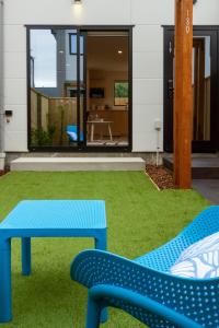 a blue bench and a table in front of a house at Sunsoaked seaside 1 bedroom 1 bath in Christchurch