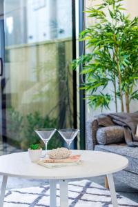 a white coffee table with two wine glasses on it at Sunsoaked seaside 1 bedroom 1 bath in Christchurch