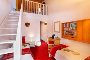 a kids room with two beds and a staircase at Hôtel du Bourg in Valmorel