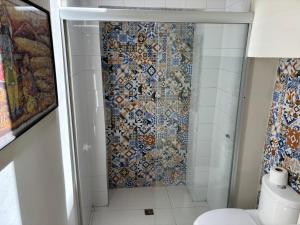 baño con ducha y pared de mosaico en Hotel Boutique Casona los Pavorreales en Durango