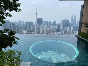 einen Infinity-Pool mit einer Skyline der Stadt im Hintergrund in der Unterkunft Harmony Luxury Suites At Lucentia Bukit Bintang City Center in Kuala Lumpur