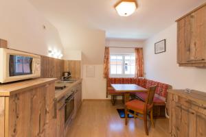 a kitchen with wooden cabinets and a table with a dining room at Schusterhäusl in Wörschach