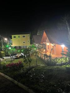 a house with a car parked in a yard at night at Chalé Suíço in Guaramiranga