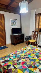 a bedroom with a colorful quilt on a bed at Suite de casa de campo in Socorro