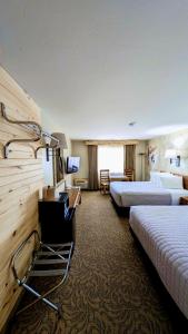 a hotel room with two beds and a television at Browns Canyon Inn in Salida