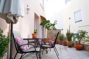 a patio with a table and chairs and potted plants at Pigadia Central in Karpathos